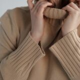 woman adjusting collar of soft sweater
