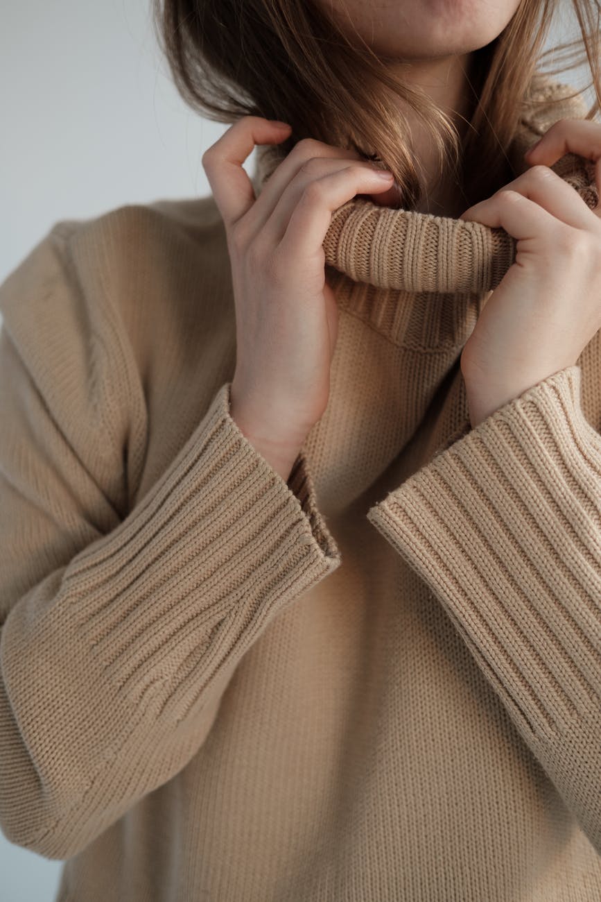 woman adjusting collar of soft sweater