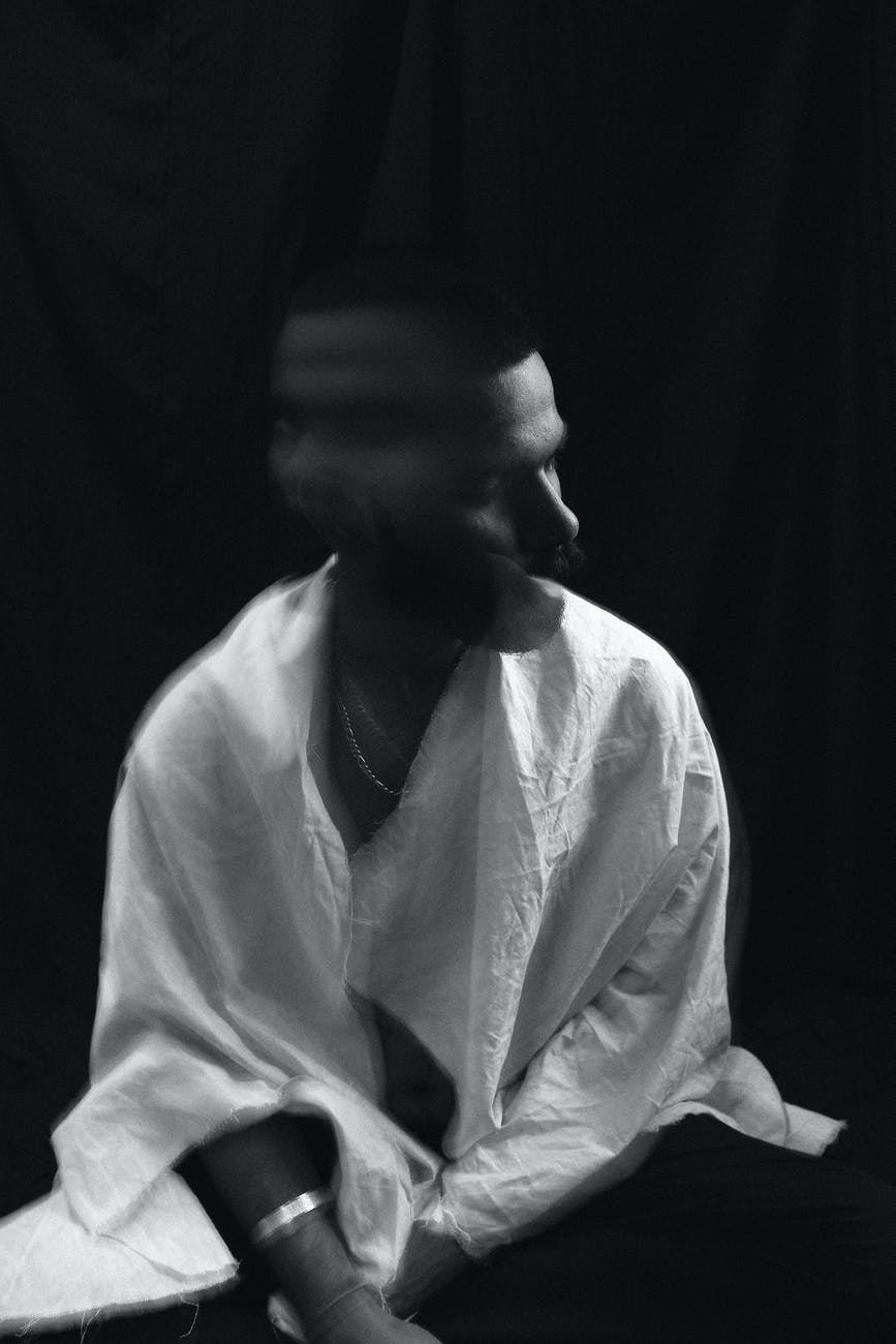 depressed young man with blurred head in dark room
