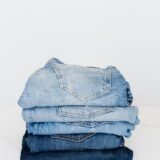 stack of jeans on white shelf