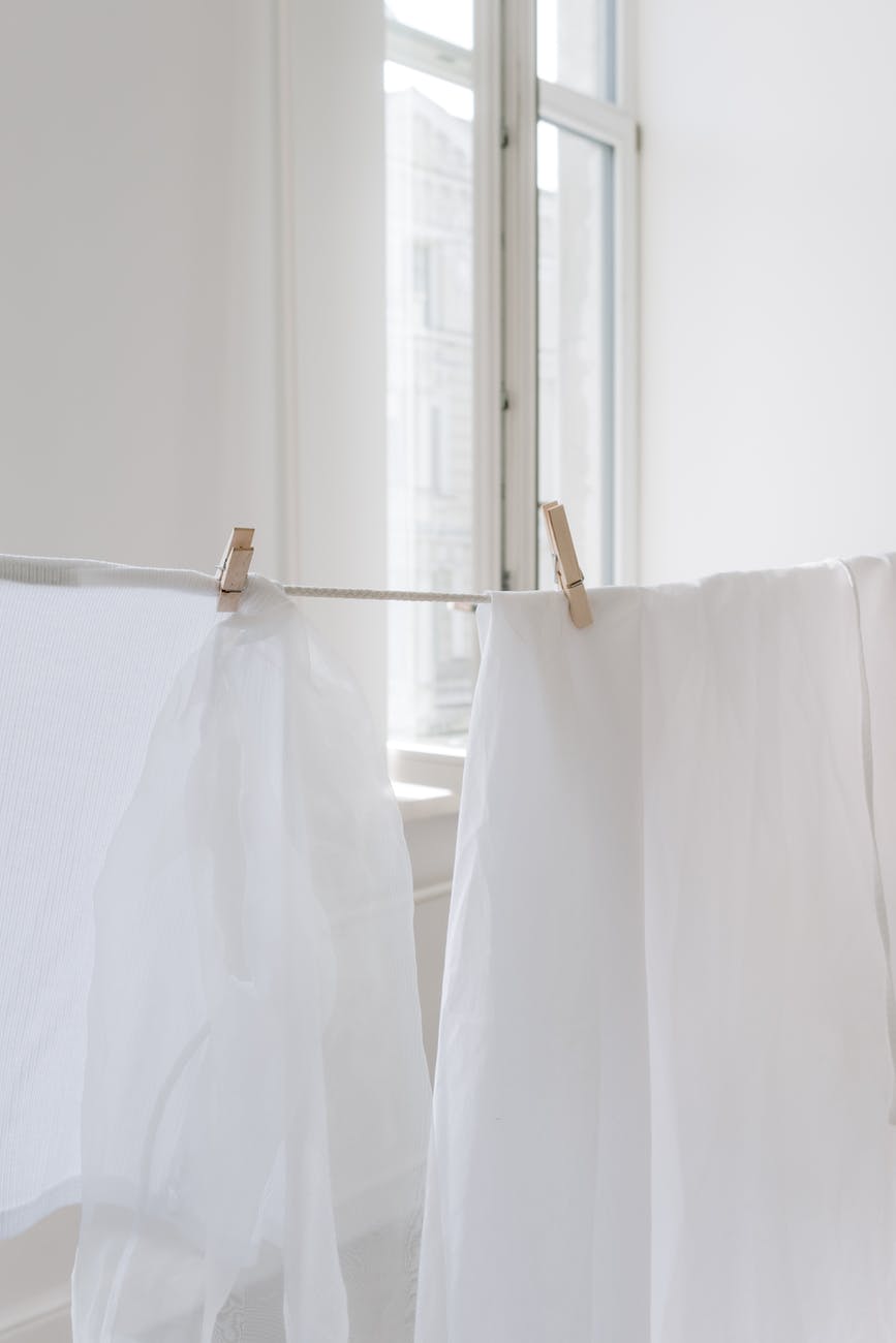 white textile on brown clothes hanger