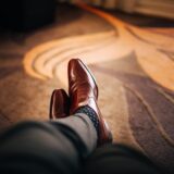 shallow focus photography of person wearing brown leather dress shoes