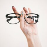 photo of person holding eyeglasses