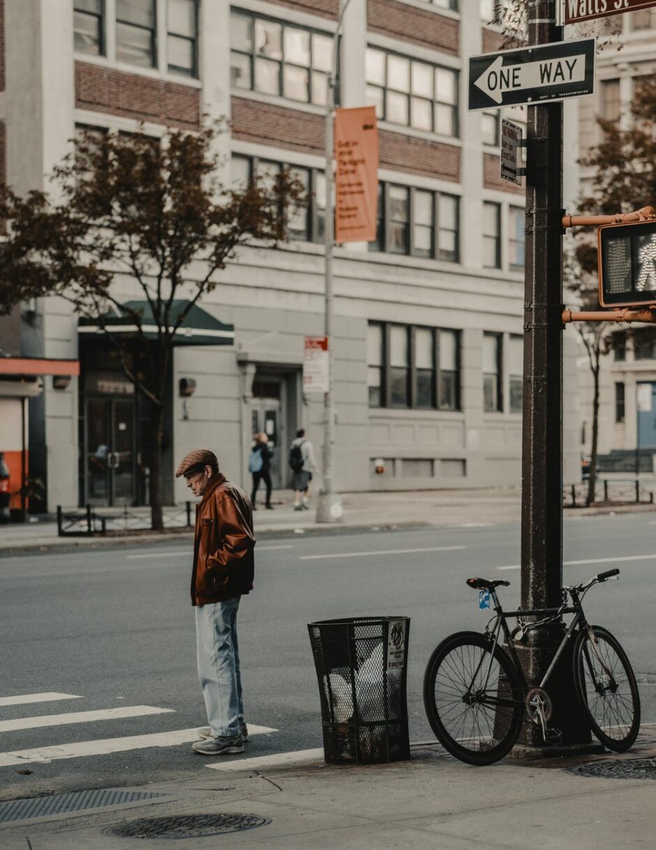 photo of man standing in pedestrian lane