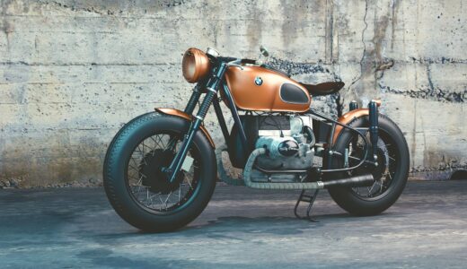 orange and black bmw motorcycle before concrete wall