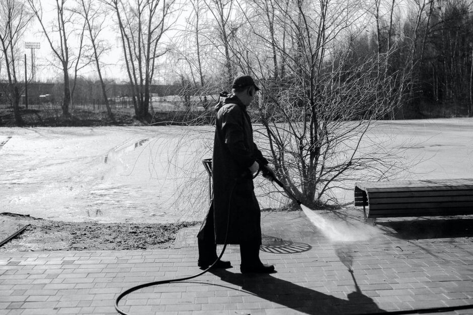 man watering pavement