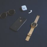 photo of iphone near sunglasses and watch