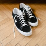 black and white converse sneakers on wooden flooring