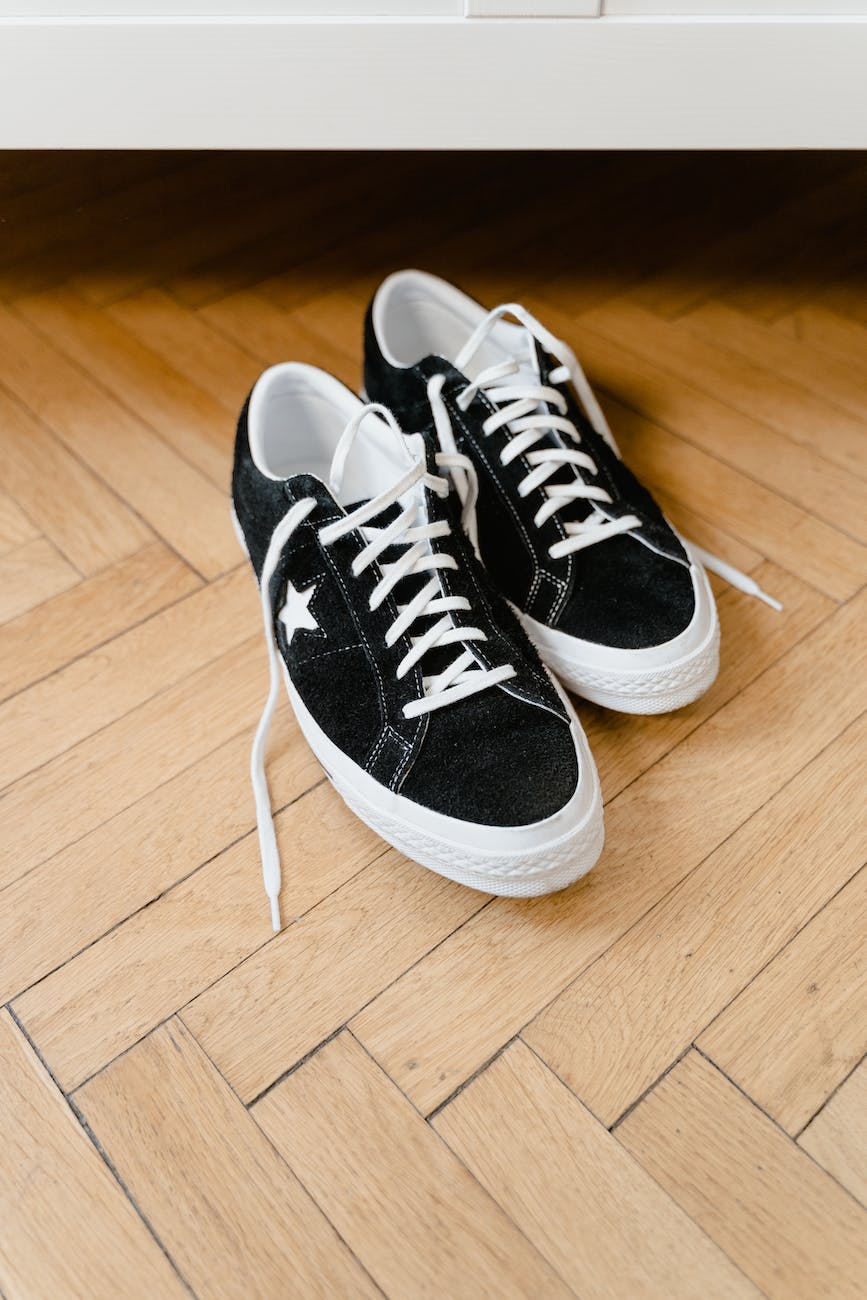 black and white converse sneakers on wooden flooring