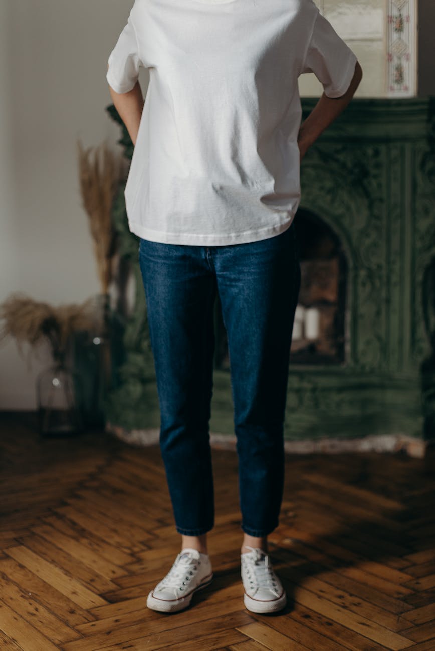 photo of person wearing white t shirt and blue denim jeans