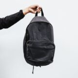 person holding black backpack