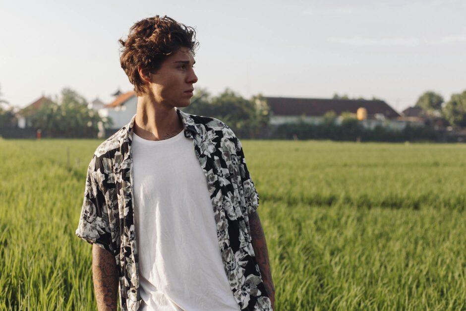 young man standing in agricultural field