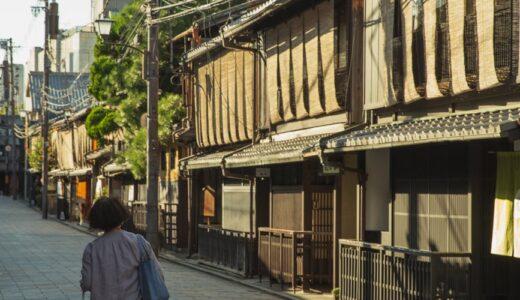 anonymous woman strolling on street near typical asian houses