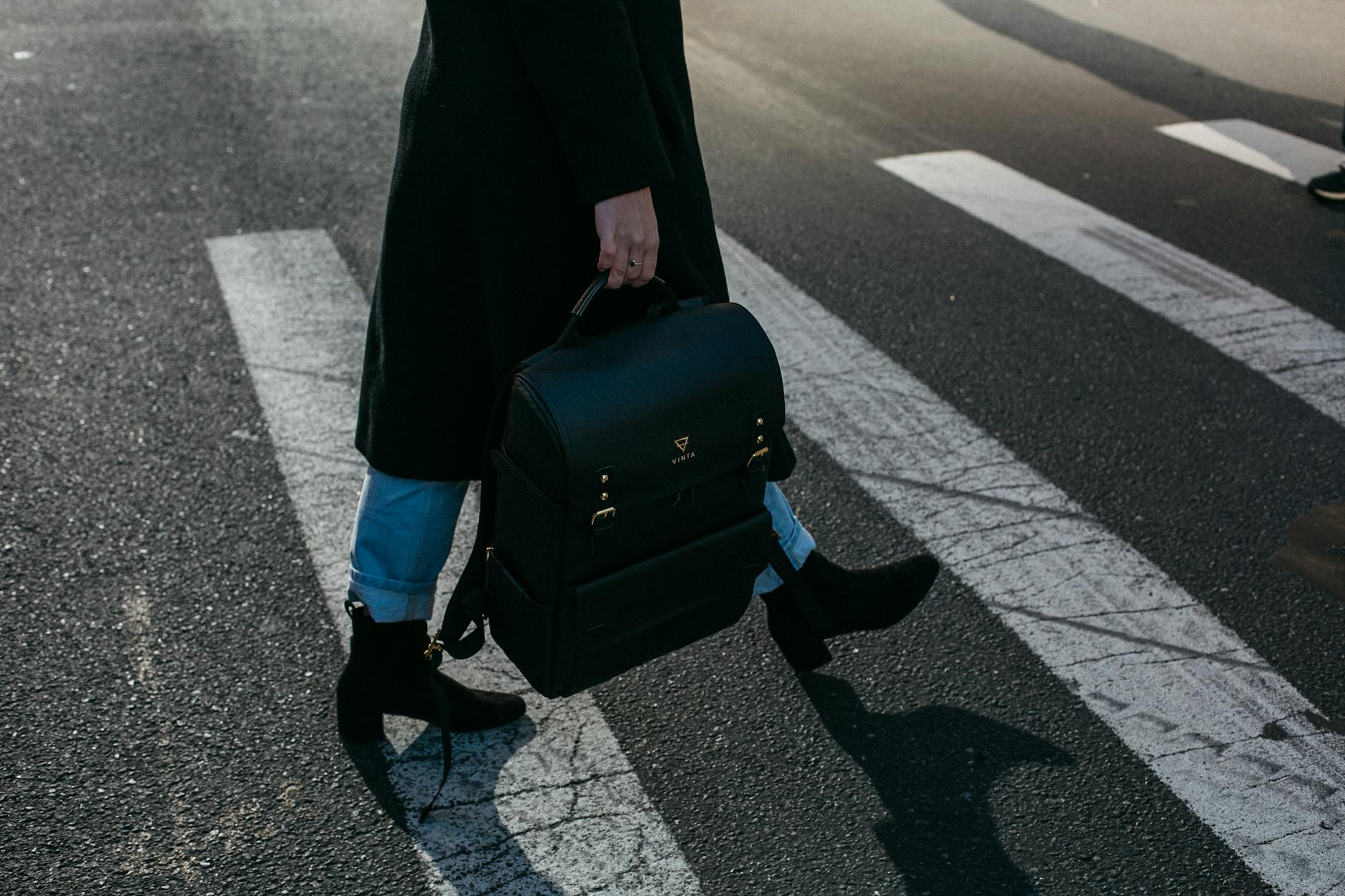 person carrying bag walking on pedestrian lane