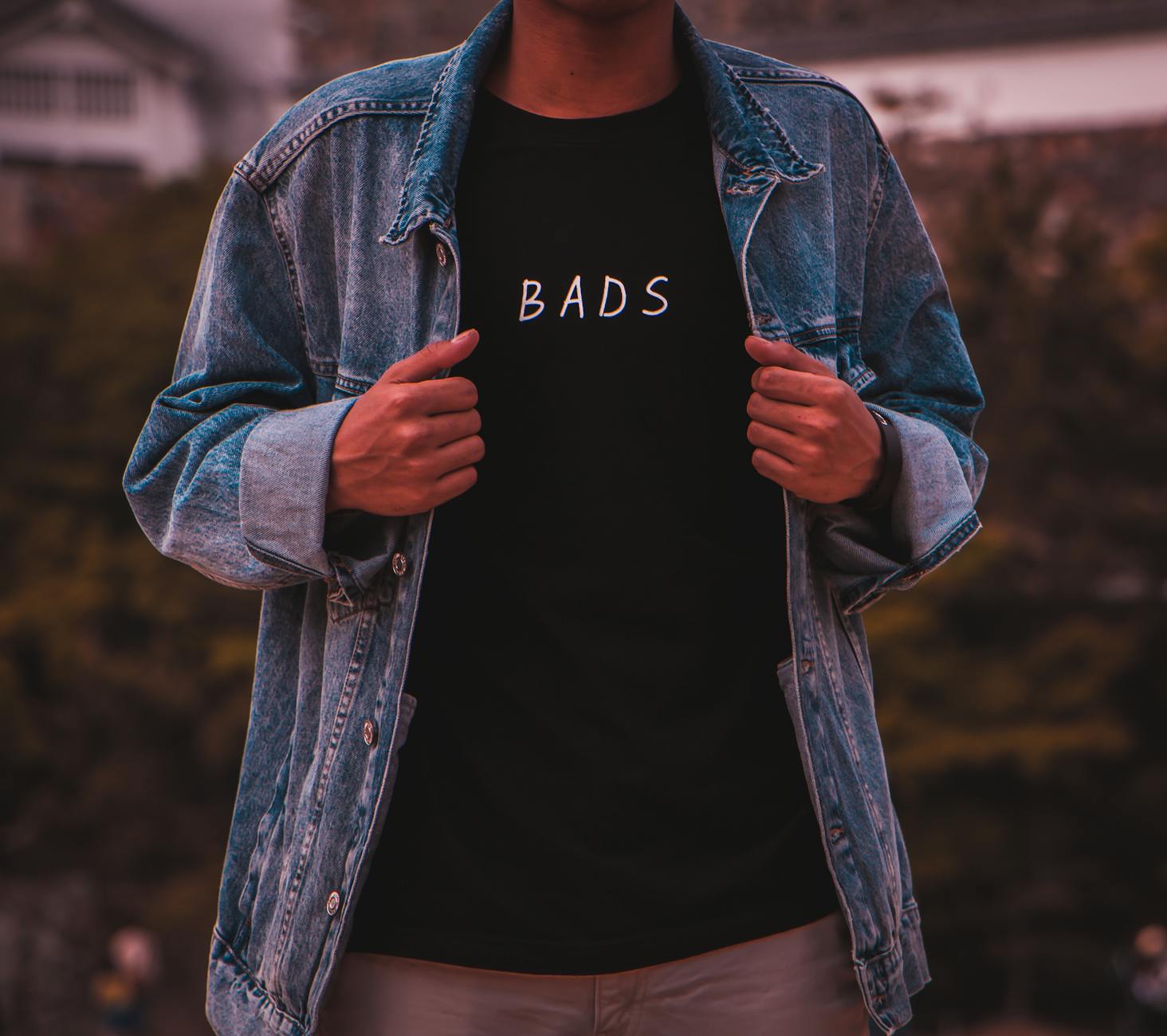 man wearing black bads crew neck shirt under blue denim jacket
