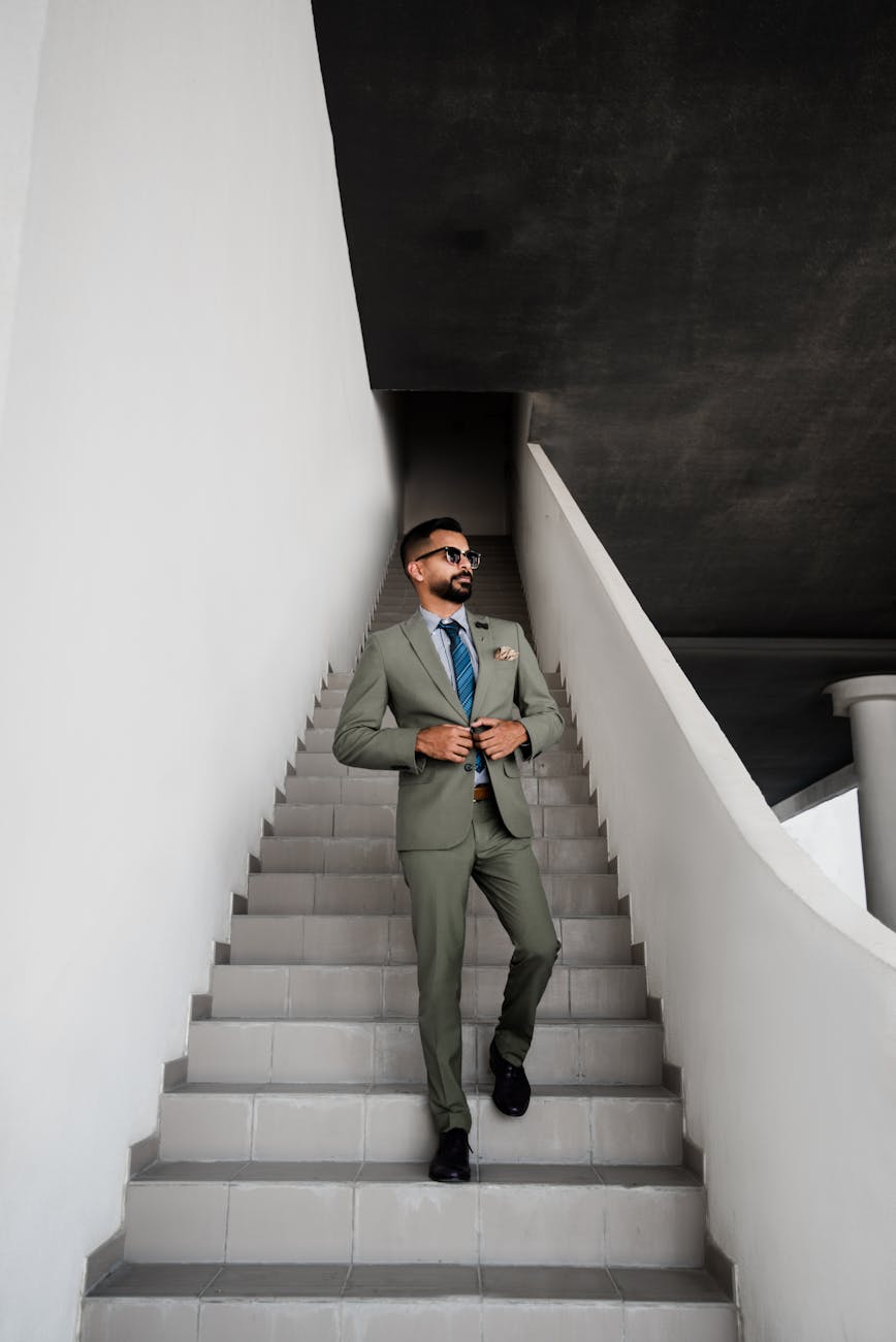 man in grey suit standing on stair