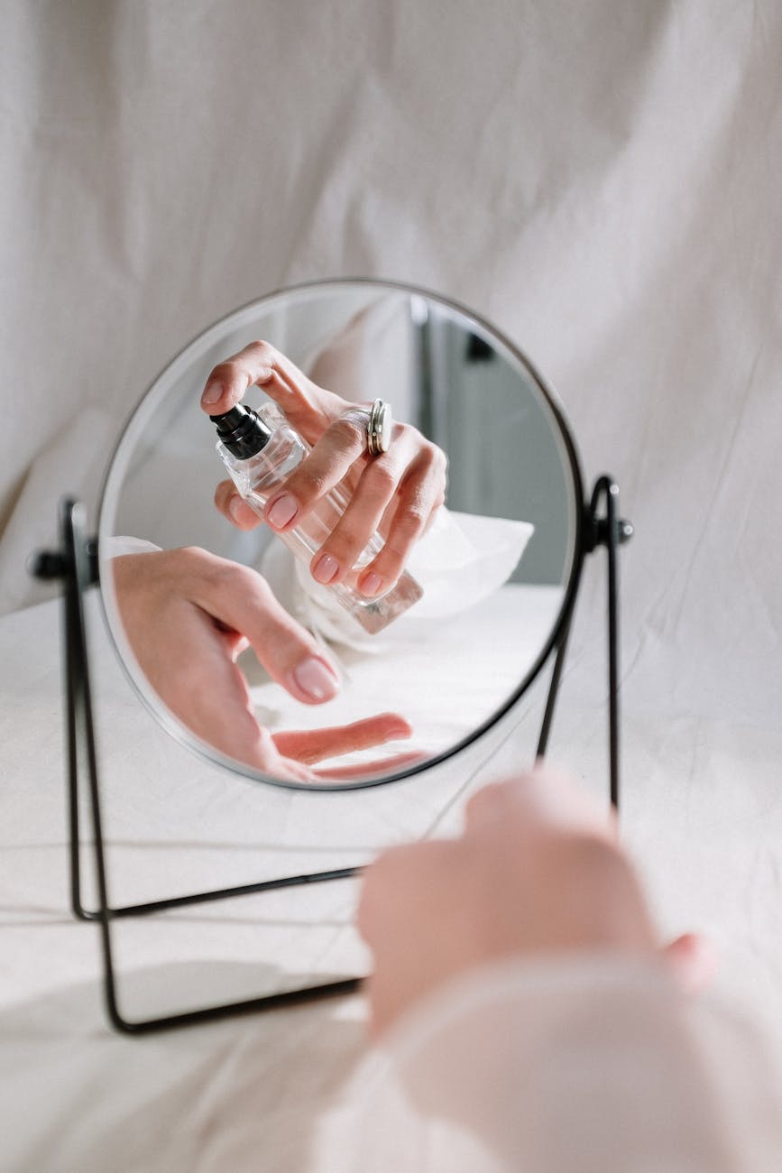 person holding clear glass round mirror