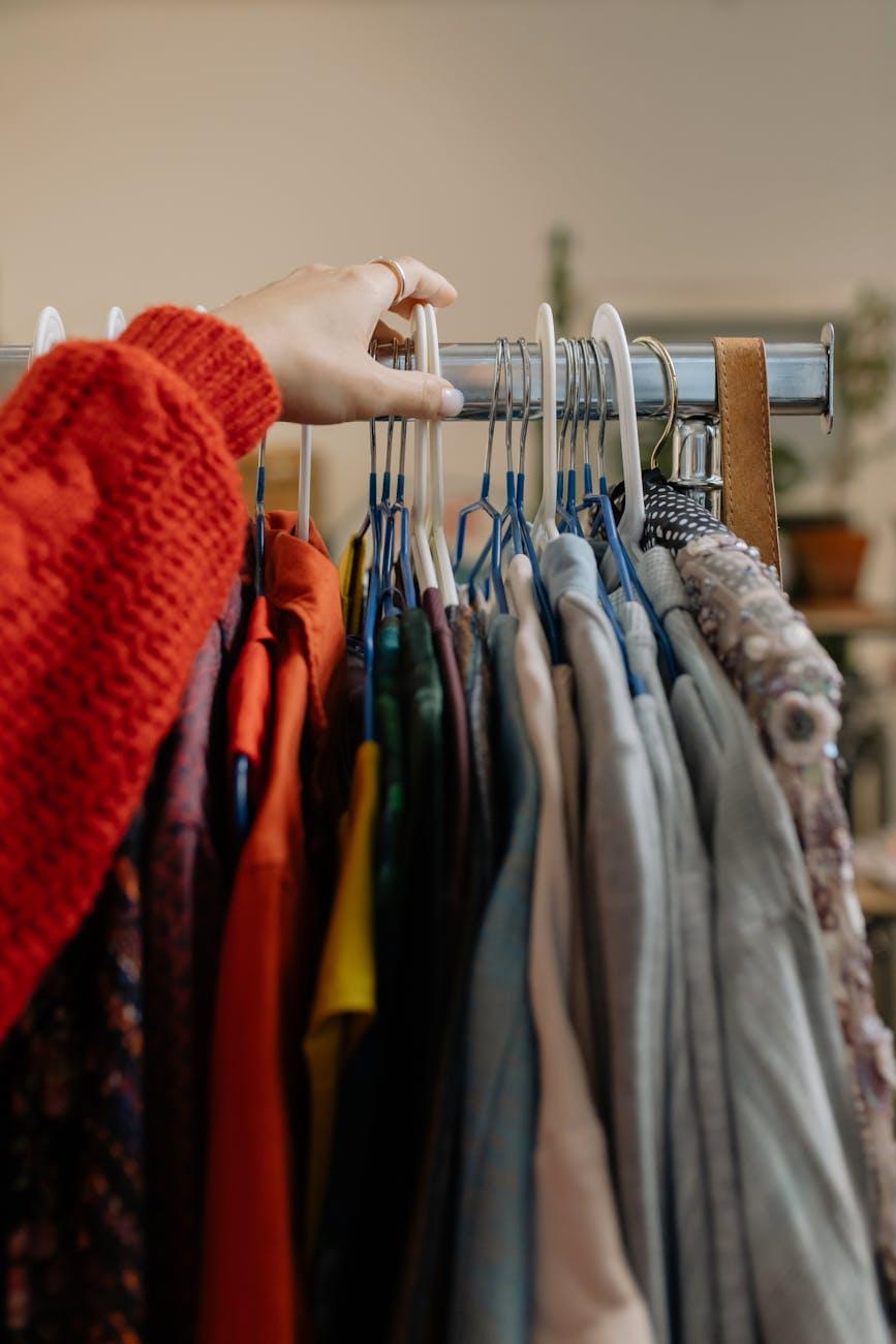 person holding clothes hanger with clothes